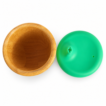 Vista cenital del interior del vaso Sippy de bambú Eco Rascals y tapa verde de silicona desmontada sobre fondo blanco